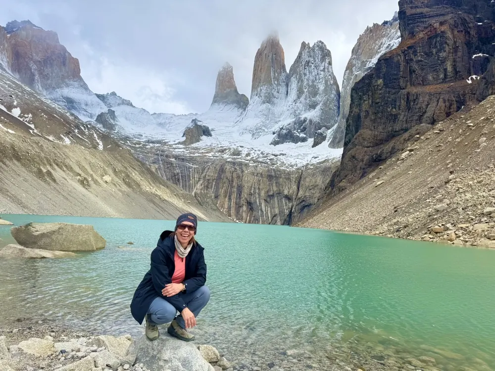 Caminante sonriendo junto a un lago glaciar